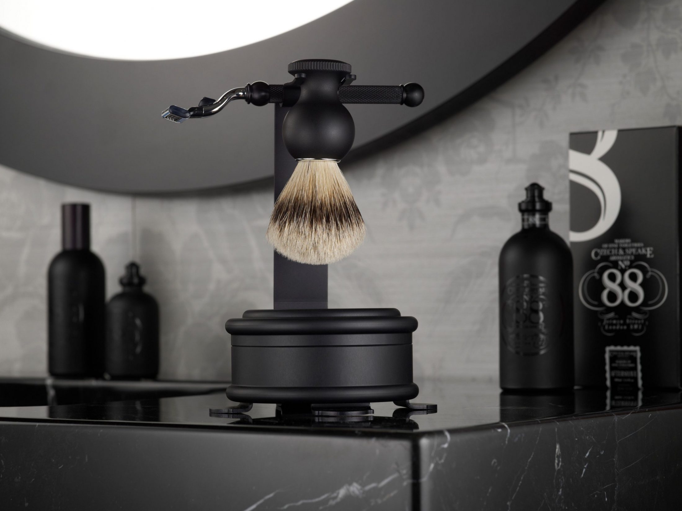 Czech & Speake No.88 Shaving Set & Stand on black marble vanity unit with fragrance behind.