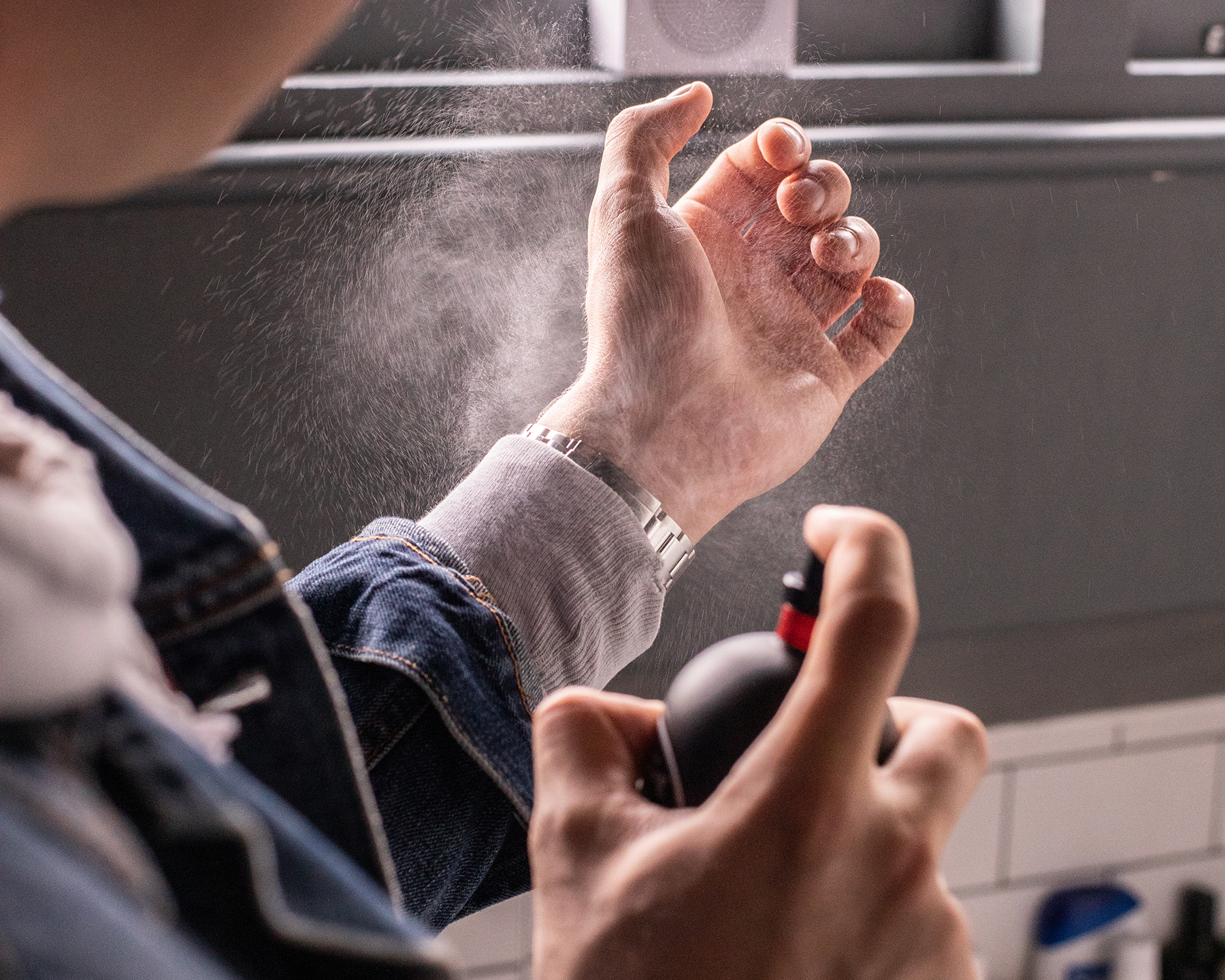 men spraying fragrance on wrist