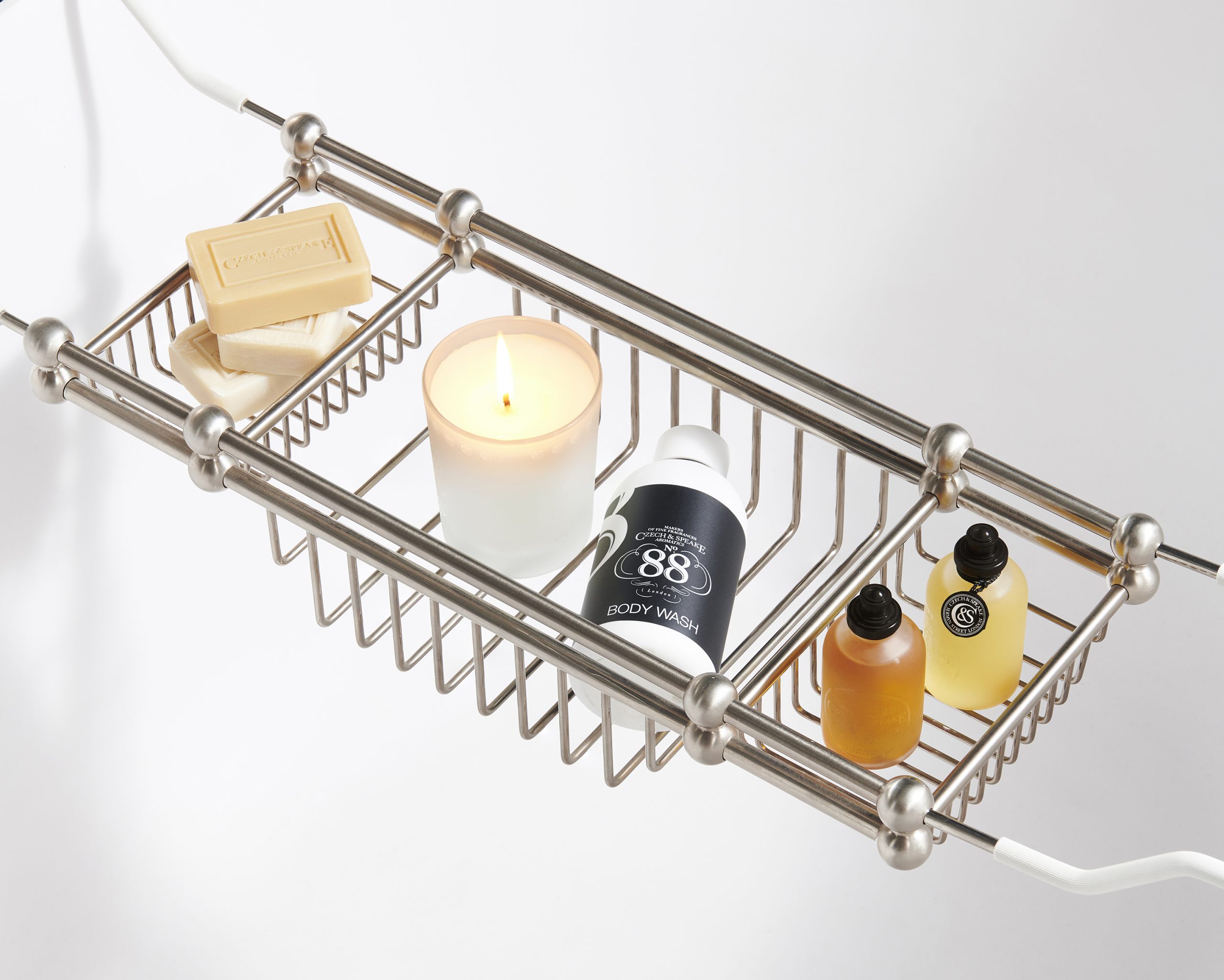 Czech & Speake Edwardian Bath Rack over a bath filled with Hand soaps, scented candle, No.88 Body Wash and Bath oils.